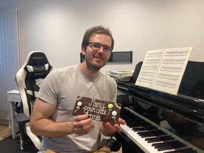 Alexandre après une journée d'enseignement du piano avec un cadeau de fin d'année d'une élève contente de ses cours.