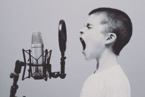Un enfant qui chante devant un micro